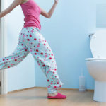 woman running to washroom with toilet paper in hand